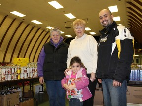 Deb Flewelling, left, and Shirley Simons of the Paris Community Christmas Hamper program got a helping hand on Wednesday, Dec. 19, 2012 from Rob Santos and his daughter Kali, 4, to ready the hampers for 140 families in need of some help to have a nice Christmas. MICHAEL PEELING/THE PARIS STAR/QMI AGENY