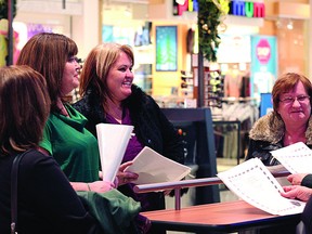 Mall carollers Tracy Aiello (left) and Carla Howatt prep their windpipes on Tuesday, Dec. 18. Leah Germain News Staff