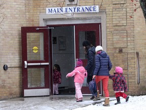 Parents and children walk into Winston Churchill Public School on Earl Street on Friday afternoon.
Ian MacAlpine The Whig-Standard