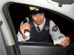 Const. Shannon Neff, community policing/media liaison for the Portage La Prairie detachment checks a drivers licence during a roadside check stop.