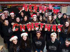 Grade eight students hold up Christmas greetings just hours before they were released for the holidays, Dec 21 2012. (QMI Agency/BOB TYMCZYSZYN)