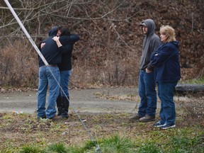 People gathered and hugged while being kept away from the scene along Route 22 near the entrance to Canoe Creek State Park, in Blair County, Pennsylvania, December 21, 2012. (REUTERS/Altoona Mirror/J.D. Cavrich)