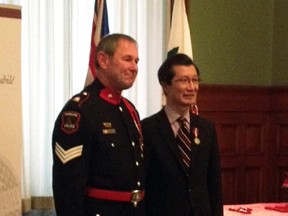 Timmins Police Service Sgt. Alan Richardson, left, receives the Queen’s Diamond Jubilee Medal.