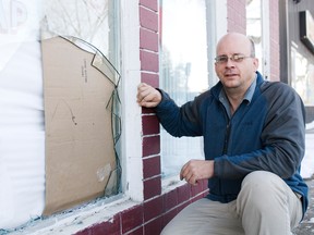 Svjetlana Mlinarevic/Portage Daily Graphic
Wil Pachluck, owner of Schapansky's Florist, kneels next to the borken glass of his front store window Friday after someone drove their car through it Thursday.