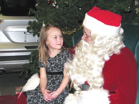 Ripleigh Athenton, 4, shares her Christmas wish with Santa Claus while having her picture taken at Kenora Shoppers Mall, Thursday. 
REG CLAYTON/Daily Miner and News
