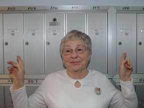 Port Stanley resident Margaret Armstrong with her left hand pointing to her old mailbox and her right hand to her new mailbox.