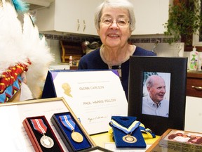 Joyce Carlson sits behind some of the many accolades received by her husband, Glenn, during his lifetime, including three Queen Elizabeth II Jubilee medals.