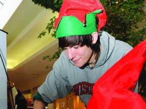 Shane Amyotte, helping out for the Leeds and Grenville OSPCA, kept his hands busy wrapping gifts at the 1000 Islands Mall charity table on a busy afternoon Sunday, the second to last day for Christmas shopping. (DARCY CHEEK/The Recorder and Times)
