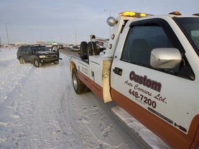 A tow truck driver with Custom Auto Carriers Ltd. and an Edmonton Police Service officer responded to a two vehicle collision in the southbound lane of Highway 2 in Edmonton, Alta., on Sunday, December 23, 2012. Police say a high number of crashes have occured due to inclement weather. Ian Kucerak/Edmonton Sun/QMI Agency