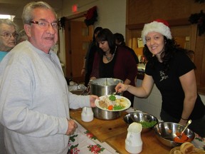 Delhi native Leanne Argoso, right, devoted her Christmas to serving others. Preparing to enjoy a delicious Christmas meal at Delhi United Church, at left, is Harry Schreck of Delhi. (MONTE SONNENBERG Delhi News-Record)