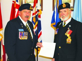 District Commander Dino Michaud presents President Owen Howe with the bylaws to officially give the charter back to the High River Legion