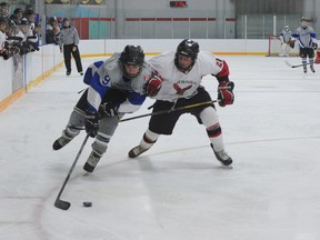 Kyle Parsons of the Hagersville Hawks, right, cuts Brad Ward of the Delhi Travellers off at the pass during third period action Boxing Day in the Southern Ontario Junior Hockey League. The conference-leading Hawks struck for two goals in the first period and hung on to defeat the surging Travellers 2-1. (MONTE SONNENBERG Simcoe Reformer)