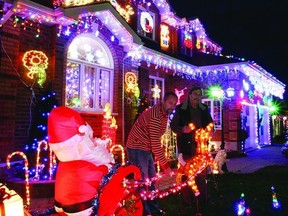 Shawn Richardson and Manny Mederios inspect one of the light displays on their home at 495 Davis Dr.  Readers can now vote for their favourites online through our poll tool.      Rob Mooy - Kingston This Week