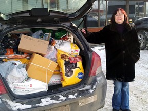 Tamara Reyes, manager of the pet-sitting business Love Them at Home Pet Care, picks up pet food donations from across Edmonton for the Hungry Bowl Pet Food Drive. DALE BOYD Special to the Examiner