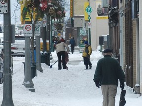 While some people took a stroll others dug out after a winter storm hit the area that brought snow and high winds during the evening and night of Boxing Day, 2012.