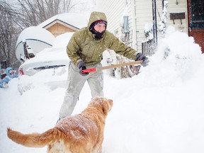 Julien Forrester, 18, clears the driveway in front of his home as the family dog Daisy looks on. The city received a wallop of a storm overnight and Thursday morning, leaving roads treacherous and many stuck inside.
Staff photo/CHERYL BRINK