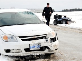 Chatham-Kent police Const. Michael Pearce walks through scene of a crash involving a vehicle and an ATV on Mull Road Thursday, December 27, 2012, south of Blenheim, On. Police said the 28-year-old man who was driving the ATV was transported to hospital with serious head injuries. The collision is under investigation.  DIANA MARTIN/ THE CHATHAM DAILY NEWS/ QMI AGENCY