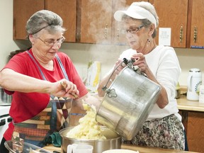Jean Pickett and Bev Lithgow get the potatoes ready for Heartland Community Church’s soup and more pre-Christmas meal on Dec. 19.