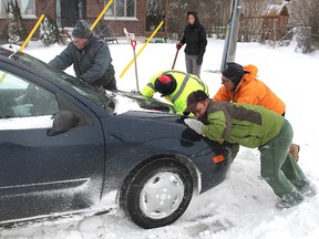A motorist stuck in the deep snow at the corner of Cataraqui Street and Orchard Street Thursday morning got some help from other motorists and passers-by to get free.
Michael Lea The Whig-Standard