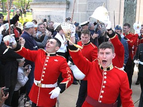 Their headgear perched on their swords, graduating cadets from the Royal Military College cheer as they march under the college's Memorial Arch Friday afternoon following their commissioning parade to complete their four years at RMC.
Michael Lea The Whig-Standard