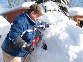 Scott Knight digs out his cars on Friday after the massive snow storm hit the city Thursday bringing in a record breaking 39 cm of snow. 
Staff photo/ERIKA GLASBERG