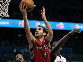 Raptors guard Jose Calderon scores on a lay-up as teammate Ed Davis  looks on and Orlando Magic forward Andrew Nicholson defends last night. (Reuters)