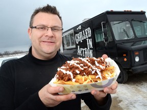 Chef Patrick Moore holds up a serving of Oinkin Fries, which are topped with smoked pulled pork, monteray jack, scallions and lime crema.