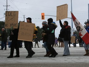 Saugeen Ojibway Nation protesters hold signs in support of First Nations Chief Theresa Spence's hunger strike Sunday at the Springmount intersection west of Owen Sound. Traffic was shut down for about 10 minutes.