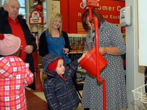 Reid Kirkham. 4, donates some change in a Salvation Army kettle at Canadian Tire during December. This year’s tally for the campaign will be announced this week. (DHT file photo)