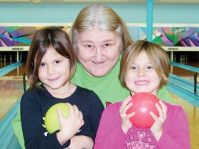 Twins Kaitlynn Cote and Madison Cote, 6, spend some time bowling with their mamere, Betty Cote, at Quilles Nativity Bowl on Saturday afternoon during the Christmas Family Bowling Challenge. 
Staff photo/ERIKA GLASBERG