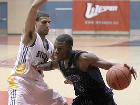 Keyano Huskies Serge Khayipangi (r) breaks past Brandon Bobcats Michael Smith during Wesmen Classic basketball in Winnipeg, Man. Sunday Dec. 30, 2012. BRIAN DONOGH/QMI Agency