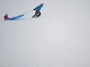 Sledders brave white-out conditions for the thrills of an icy Fort Henry Hill on Saturday. (Jeff Peters For The Whig-Standard)