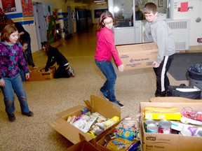 Students from Jen Lessard's grade 5 class at Queen Elizabeth Public School in Trenton are seen here on Dec. 20 boxing up more than 700 items collected during a recent food drive. The items were donated to the Trenton Care and Share Food Bank.   

EMILY MOUNTNEY/TRENTONIAN/QMI AGENCY