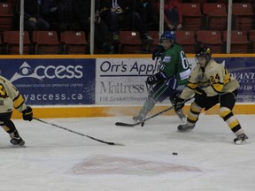 The Melfort Mustangs' Jay Aasen avoids a check and makes a pass during the Mustangs loss to the visiting Nipawin Hawks on New Year's Eve.