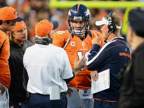 Head Coach John Fox and Offensive Coordinator Mike McCoy talk with Peyton Manning #18 of the Denver Broncos during the game against the Tampa Bay Buccaneers at Sports Authority Field at Mile High on December 2, 2012 in Denver, Colorado.   Garrett W. Ellwood/Getty Images/AFP