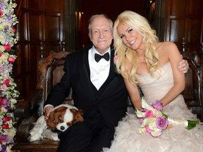 Octogenarian Playboy founder Hugh Hefner poses with his bride Crystal Harris and dog Charlie at their New Year Eve wedding at the Playboy Mansion in Beverly Hills, California in this handout photo taken on December 31, 2012. Hefner briefly swapped his iconic silk pajamas for a tuxedo to marry Harris, the one-time "runaway bride" who followed through this time at the New Year's Eve wedding. The couple tied the knot more than a year after their planned 2011 wedding was scuttled when Harris got cold feet. REUTERS/Elayne Lodge/PEI/Handout