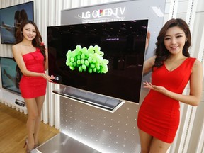 Models pose next to LG Electronics' organic light-emitting diode (OLED) television in Seoul Jan. 2, 2013. REUTERS/Lee Jae-Won