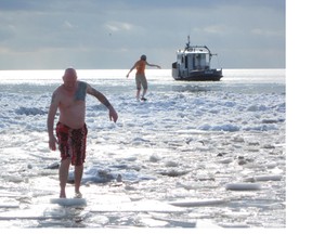The bare-footed Sean Kavanagh of Paris gingerly makes his way back to shore after participating in the annual New Year's Polar Bear Dip in Port Dover. (MONTE SONNENBERG Simcoe Reformer)