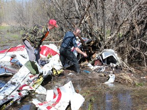 Rescuers looked through wreeckage after the mid-air collison above St. Brieux in May.