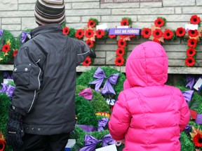 Two youngsters pause to pay their respects at the memorial during Remembrance Day services in South Porcupine in November.