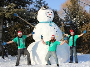 Brothers Tamas, left, Kalman and Norbert Kallai stand in front of the 12-foot snowman their family built at 22606 Pioneer Line near near Rodney just after Christmas.