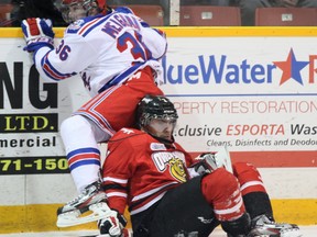 Curtis Meighan of the Kitchener Rangers flies into the boards after colliding with Owen Sound Attack forward Daniel Catenacci during first-period OHL action at the Harry Lumley Bayshore Community Centre on Wednesday. The Rangers beat the Attack 3-1.