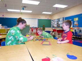 Fairview Playschool volunteer Megan Ganter plays dominos with Lowen Chailler and Matthew Johnson. To celebrate the last day of playschool before Christmas students and staff wore their pyjamas in class. (Chris Eakin/Fairview Post)