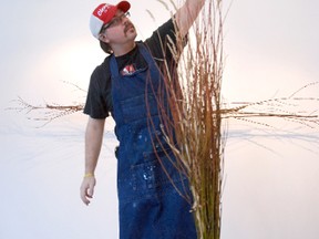 Dan Arberry looks over one of the art installation pieces in his exhibit, Silencing the Voices. The artwork, which will be open to the public starting on Friday at the Centre for Creative Arts, uses materials such as branches, twigs and grasses to cast shadows on walls, creating a drawing. (Kirsten Goruk/Daily Herald-Tribune)