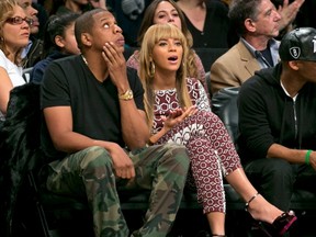 Entertainers Beyonce and Jay-Z  watch the Brooklyn Nets play the Toronto Raptors  in the fourth quarter of their NBA basketball game in New York, November 3, 2012. REUTERS/Ray Stubblebine