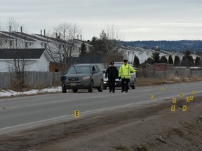 Police officers survey the scene of a fatal pedestrian collision on Queen Street East that killed Matt Howard, 19, in February 2010.