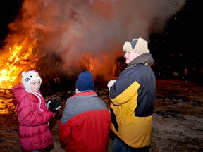From left, Sarah, Nicholas and Terry Julien enjoy the Athens Community Bonfire. RONALD ZAJAC The Recorder and Times