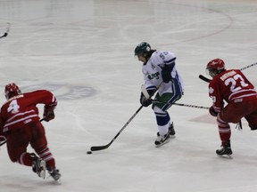 The Melfort Mustangs' Logan Sceviour puckhandles between two Notre Dame Hounds during the Mustangs' 4-1 victory on Saturday, January 5 at the Northern Lights Palace.
