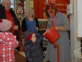Reid Kirkham. 4, donates some change in a Salvation Army kettle at Canadian Tire during the month of December. The totals are in from this year's campaign and the Salvation Army is worried about how not meeting the fundraising goal with affect the year to come. (PATRICK CALLAN/DAILY HERALD-TRIBUNE/QMI AGENCY)
