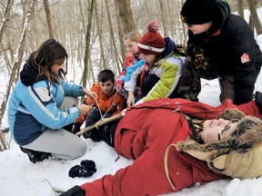 Chatham Scout Dorothy Cofell, 12, left,cuts the rope used to tie a makeshift splint on Scout leader Lila-Kay Collins from the 81st Cubs from London, On., during the Mowgli's Winter Adventure camp at Camp Cataraqui near Duart, On.. Cubs, Scouts and Venturers from Chatham #4 Troop and cubs from 81st London learned survival skills during the Yukon Iditarod themed weekend camp. PHOTO TAKEN January 05, 2013, Duart, ON.DIANA MARTIN/ THE CHATHAM DAILY NEWS/ QMI AGENCY